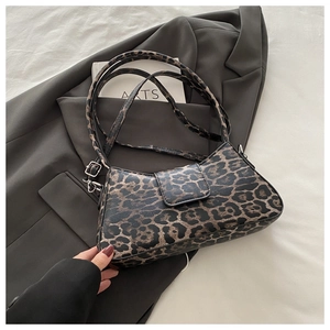 Gros plan du sac baguette léopard avec boucle métallique et fine bandoulière réglable