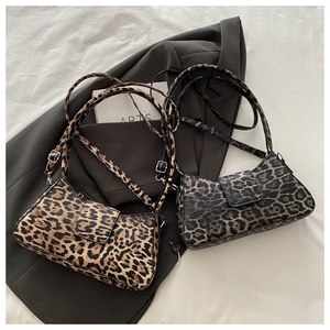 Détail de sacs à bandoulière motif léopard avec sangle réglable sur un blazer gris