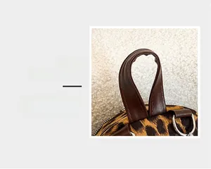 Detail magnification of the leopard print faux suede bag with brown leather top handle