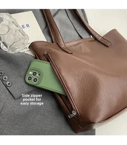 Close-up of a brown tote bag featuring a side zipper pocket for smartphone storage