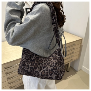 Détail du sac léopard avec bandoulière à volants et texture du tissu en gros plan