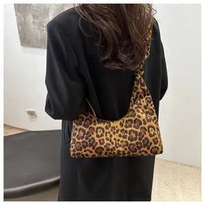 Détail d'un grand sac cabas à imprimé léopard en velours porté à l'épaule sur un mannequin