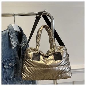Detail of champagne gold quilted puffer tote bag with adjustable black nylon strap