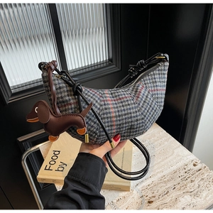 Detail der karierten Horn Bag mit Lederknotengurt und süßem Dackel Anhänger