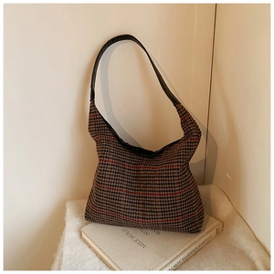Macro detail of retro houndstooth pattern fabric and leather strap on tote shoulder bag