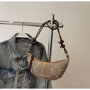 Detail der Hahnentritt-Halbmondtasche mit geflochtenem Knotenschultergurt und Reißverschluss