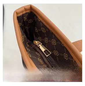 Detailed macro view of the gold metal zipper and branded textile lining on a tote bag