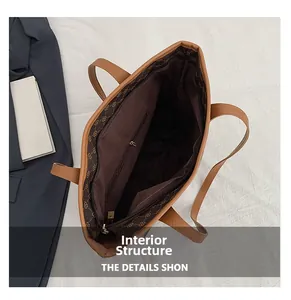 Detail view of the brown tote bag interior featuring a zippered pocket and logo lining