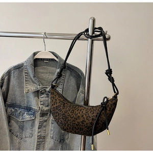 Nahaufnahme der Leoparden-Halbmondtasche mit geknoteten Riemen und goldenem Reißverschluss