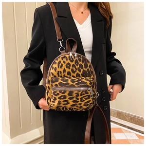 Close-up of stylish leopard print faux suede mini backpack worn with a black blazer