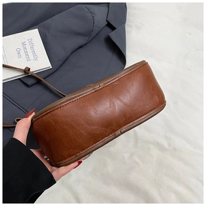 Detail shot of vintage brown PU leather bag base and fine stitching with shoulder strap
