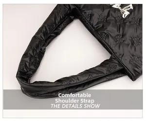 Close-up of black quilted nylon shoulder bag with bow-shaped stitching and metal bow detail