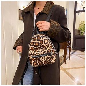 Detail of leopard print suede mini backpack featuring front zipper and slim black straps