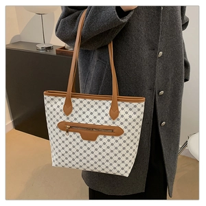 Detail view of vintage printed tote bag with leather straps and golden zipper pocket