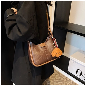 Hobo shoulder bag in brown vintage leather with teddy bear charm on model view