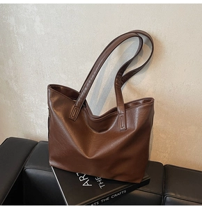 Detailed macro view of dark brown leather texture on a high-capacity tote bag