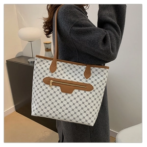 Close-up of vintage patterned tote bag with brown straps worn on a female model