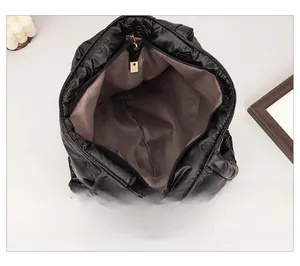 Internal view of the black quilted tote bag showing spacious lining and zipper detail