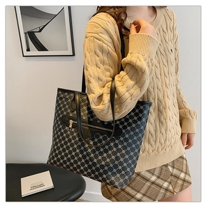 Detail of vintage patterned tote bag with metal zipper pocket styled on a model