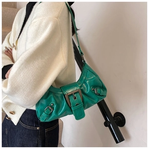 Green leather underarm bag with vintage metal buckles shown on model for daily use