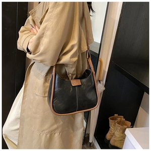 Detail view of black vintage leather tote bag with brown straps and FASHION logo text