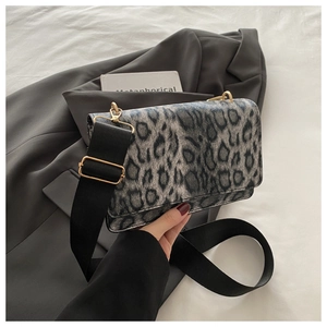 Detail of leopard print crossbody bag with wide strap on grey blazer for winter fashion