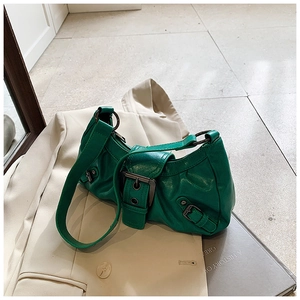 Detail of green wrinkled leather shoulder bag with vintage metal buckles and ring accents