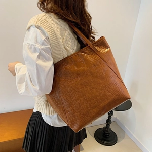 Brown crocodile embossed tote bag with large capacity, shown on model for stylish commute