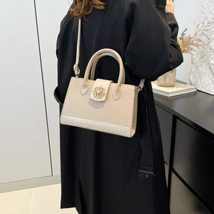 Bolso beige de moda con textura de piel de cocodrilo y hebilla floral dorada retro