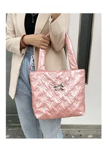 Detail of pink quilted tote bag featuring bow patterns and a silver metallic bow buckle
