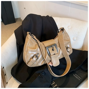 Detail of khaki crescent shoulder bag with vintage metal buckle on a black jacket