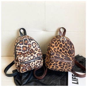 Detail of leopard print suede mini backpacks in cream and tan colors with silver zippers
