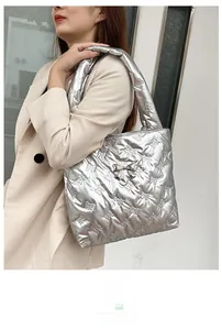 Close-up of silver quilted tote bag with bow texture and metal bow decoration