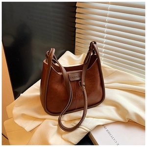 Macro view of vintage brown oiled leather texture and FASHION embossed logo tag on handbag