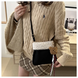 Detail of plush crossbody bag with teddy fur trim and a cute brown bear charm