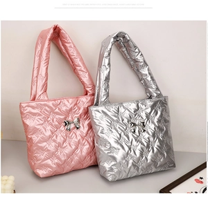 Detail of pink and silver quilted tote bags with embossed bow texture and metal hardware