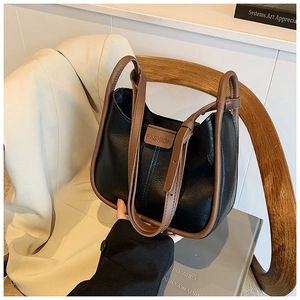 Detail of vintage bucket bag with black pebbled leather and contrast brown trim