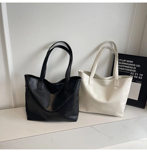 Minimalist black and white large tote bags shown in a clean indoor setting