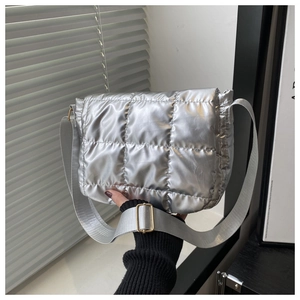 Detail of silver quilted crossbody bag with adjustable strap and square stitching