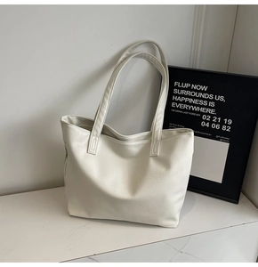 Detail shot of off-white tote bag with natural wrinkled faux leather texture on marble surface