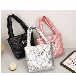 Close-up of quilted bow pattern tote bags in black, silver, and pink metallic finish