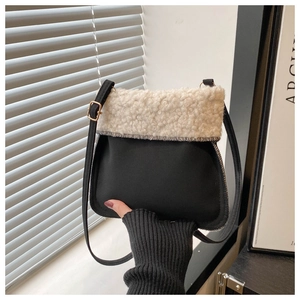 Detail of black matte crossbody bag featuring plush beige faux shearling trim and strap
