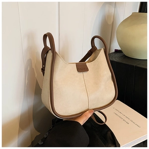 Close-up of cream crescent crossbody bag with brown leather trim and FASHION label detail