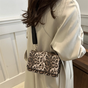 Classic leopard print crossbody bag with wide black strap and plush vintage texture
