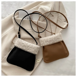 Close-up of black and brown plush fleece trimmed mini shoulder bags with metal buckles