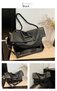 Detail of black faux leather tote featuring woven rope handles and wide textile strap
