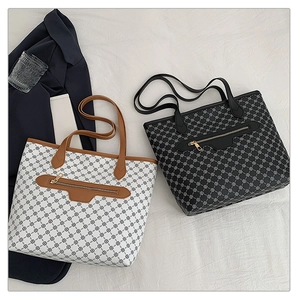 Detail of vintage tote bags with clover pattern and front zipper pocket on white fabric
