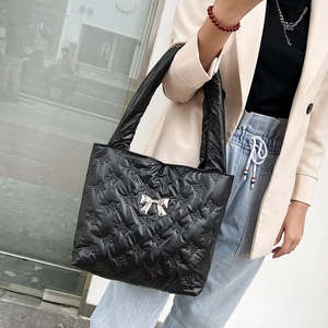 Quilted black tote bag with bow texture and silver metallic bow detail for women