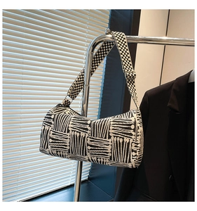 Detailed view of checkered nylon tote bag with wide strap on minimalist hanger