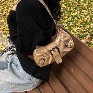 Chic tan faux leather croissant shoulder bag with pleated texture and metal buckle detail